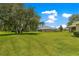Expansive backyard featuring lush green grass and mature trees offering a serene outdoor space at 8 Diamond Club Rd, Ocala, FL 34472