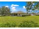 Well-maintained backyard with lush green lawn, screened-in porch, and mature trees at 8 Diamond Club Rd, Ocala, FL 34472