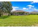 View of the backyard, house, and screen enclosed patio with well manicured lawn at 8 Diamond Club Rd, Ocala, FL 34472