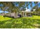 View of the rear of the house showcasing the patio and lush, well-maintained backyard at 8 Diamond Club Rd, Ocala, FL 34472