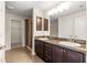 Bathroom featuring a double vanity with dark wood cabinets, tile floors, and a glass-enclosed shower at 8 Diamond Club Rd, Ocala, FL 34472
