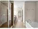 Bathroom featuring a glass-enclosed shower, soaking tub, and a double vanity at 8 Diamond Club Rd, Ocala, FL 34472