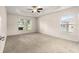 Spacious bedroom with neutral carpet, tray ceiling, and large windows providing natural light at 8 Diamond Club Rd, Ocala, FL 34472