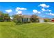 A charming single story home featuring a lush green lawn, manicured shrubbery, and vibrant landscaping at 8 Diamond Club Rd, Ocala, FL 34472