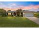 Inviting home with lush lawn, mature landscaping, and attached two car garage at 8 Diamond Club Rd, Ocala, FL 34472