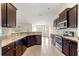 Modern kitchen featuring dark wood cabinets, granite countertops, and stainless steel appliances at 8 Diamond Club Rd, Ocala, FL 34472