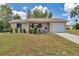 Inviting single-story home featuring a well-manicured lawn, charming porch, and attached garage at 8144 Sw 108Th Street Rd, Ocala, FL 34481