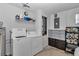 Well-organized laundry room with washer, dryer, storage shelves, and laminate flooring at 8144 Sw 108Th Street Rd, Ocala, FL 34481