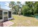 View of backyard with green chain link fence, brick pavers, and an enclosed porch at 8247 Sw 105Th Pl, Ocala, FL 34481