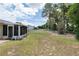 Wide open backyard with a well-maintained lawn, chainlink fence, and screened in porch at 8247 Sw 105Th Pl, Ocala, FL 34481
