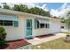 Charming single-story home with well-kept lawn, accented by a delightful turquoise door and awnings at 8247 Sw 105Th Pl, Ocala, FL 34481