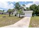Charming single-story home with well-kept lawn, accented by palm trees and a delightful turquoise door and awnings at 8247 Sw 105Th Pl, Ocala, FL 34481