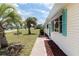 Charming single-story home with well-kept lawn, accented by palm trees and a delightful turquoise door and awnings at 8247 Sw 105Th Pl, Ocala, FL 34481