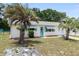 Charming single-story home with well-kept lawn, accented by palm trees and a delightful turquoise door and awnings at 8247 Sw 105Th Pl, Ocala, FL 34481