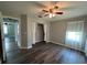 Bedroom showcasing hardwood-style floors, ceiling fan and window, and walk-in closet at 8320 Sw 108Th Place Rd, Ocala, FL 34481
