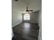Bedroom with wood-look floors, ceiling fan, and large window providing ample natural light at 8320 Sw 108Th Place Rd, Ocala, FL 34481