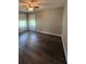 Neutral colored bedroom with two windows, ceiling fan, and dark wood-look floors at 8320 Sw 108Th Place Rd, Ocala, FL 34481