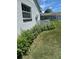 Charming exterior view features lush landscaping, a window and a decorative white lattice fence at 8320 Sw 108Th Place Rd, Ocala, FL 34481