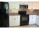 Functional kitchen featuring white cabinets, black appliances, and ample counter space at 8320 Sw 108Th Place Rd, Ocala, FL 34481