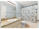 This bathroom features a granite vanity and a shower and tub with a patterned curtain at 8400 Sw 90Th St # C, Ocala, FL 34481