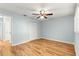 This bedroom features a closet, wood floors, a ceiling fan, and light blue walls at 8400 Sw 90Th St # C, Ocala, FL 34481