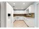 Bright kitchen boasts white cabinets, granite counters, tile backsplash and floors, and modern appliances at 8400 Sw 90Th St # C, Ocala, FL 34481