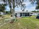 A nice backyard with a large tree, well-maintained grass, and a grill and patio set at 8547 Sw 106Th Pl, Ocala, FL 34481