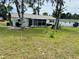 Spacious backyard with a well-kept lawn, mature trees, a shed, and outdoor equipment at 8547 Sw 106Th Pl, Ocala, FL 34481