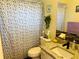 Bathroom features a single sink vanity, tile accent wall, and shower with patterned curtain at 8547 Sw 106Th Pl, Ocala, FL 34481