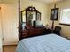 Bright bedroom with a wooden four-poster bed, dresser, and large mirror at 8547 Sw 106Th Pl, Ocala, FL 34481