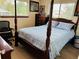Bedroom with a four-poster bed, wooden floors, and natural light from two windows at 8547 Sw 106Th Pl, Ocala, FL 34481