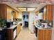 Well-lit kitchen with wooden cabinets, modern appliances, and adjacent laundry area for convenience at 8547 Sw 106Th Pl, Ocala, FL 34481