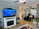 Bright living room featuring an electric fireplace, hardwood floors, and stylish decor leading into the dining area at 8547 Sw 106Th Pl, Ocala, FL 34481