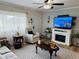 Cozy living room featuring an electric fireplace, hardwood floors, and large windows at 8547 Sw 106Th Pl, Ocala, FL 34481