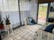 The sunroom is bright, comfortable and inviting with sheer curtains and nice furniture at 8547 Sw 106Th Pl, Ocala, FL 34481