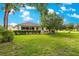 View of the rear of the home showcasing a screened lanai and manicured lawn at 8566 Sw 83Rd Loop, Ocala, FL 34481