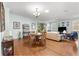 Open-concept living room with hardwood floors and dining area filled with natural light from the large windows at 8566 Sw 83Rd Loop, Ocala, FL 34481