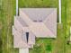 An aerial view showcasing a well-maintained roof and backyard with green grass surrounded by a white fence at 10151 Sw 41St Ter, Ocala, FL 34476