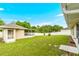 Expansive backyard with a screened-in lanai, lush green grass, and partial fencing provides a private outdoor oasis at 10151 Sw 41St Ter, Ocala, FL 34476