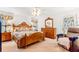 Bright bedroom with light-colored walls, wooden furniture, and patterned bedding at 10151 Sw 41St Ter, Ocala, FL 34476