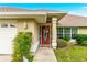 Close-up of the red front door with decorative wreath and well-maintained landscaping at 10151 Sw 41St Ter, Ocala, FL 34476