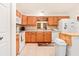 Functional kitchen featuring wooden cabinets, white appliances, and tile floors at 10151 Sw 41St Ter, Ocala, FL 34476