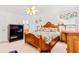 A traditional main bedroom features a wooden bed frame, a TV cabinet and light bright walls at 10151 Sw 41St Ter, Ocala, FL 34476