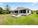 Backyard featuring lush green grass, a comfortable patio set and well-manicured landscaping at 11728 Se 91St Cir, Summerfield, FL 34491
