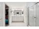 Bathroom with double sinks, white cabinets, tiled floors, and walk-in shower at 11728 Se 91St Cir, Summerfield, FL 34491