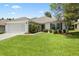 A lovely single-Gathering home features a well-kept lawn, a two-car garage and mature shrubbery at 11728 Se 91St Cir, Summerfield, FL 34491