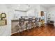 Open-concept kitchen with barstool seating, modern appliances, and hardwood floors at 11728 Se 91St Cir, Summerfield, FL 34491