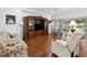 A cozy living area offers hardwood floors, comfortable seating and plenty of natural light at 11728 Se 91St Cir, Summerfield, FL 34491
