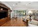A spacious living area flows into a sunroom with plenty of comfortable seating and hardwood floors at 11728 Se 91St Cir, Summerfield, FL 34491