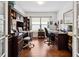 Home office with hardwood flooring, built-in shelving, and two computer workstations at 11728 Se 91St Cir, Summerfield, FL 34491